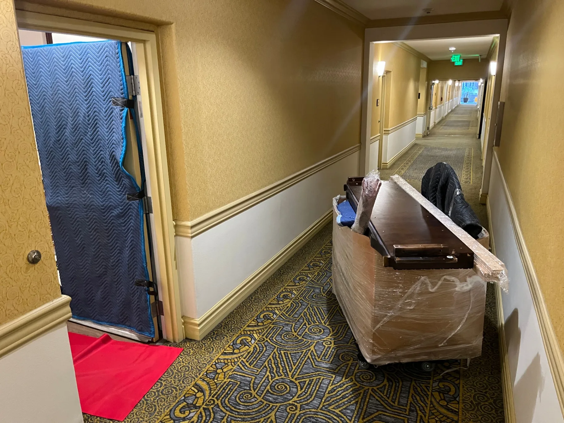 Padded furniture and door protection in a hotel hallway during a Green Echo Movers job