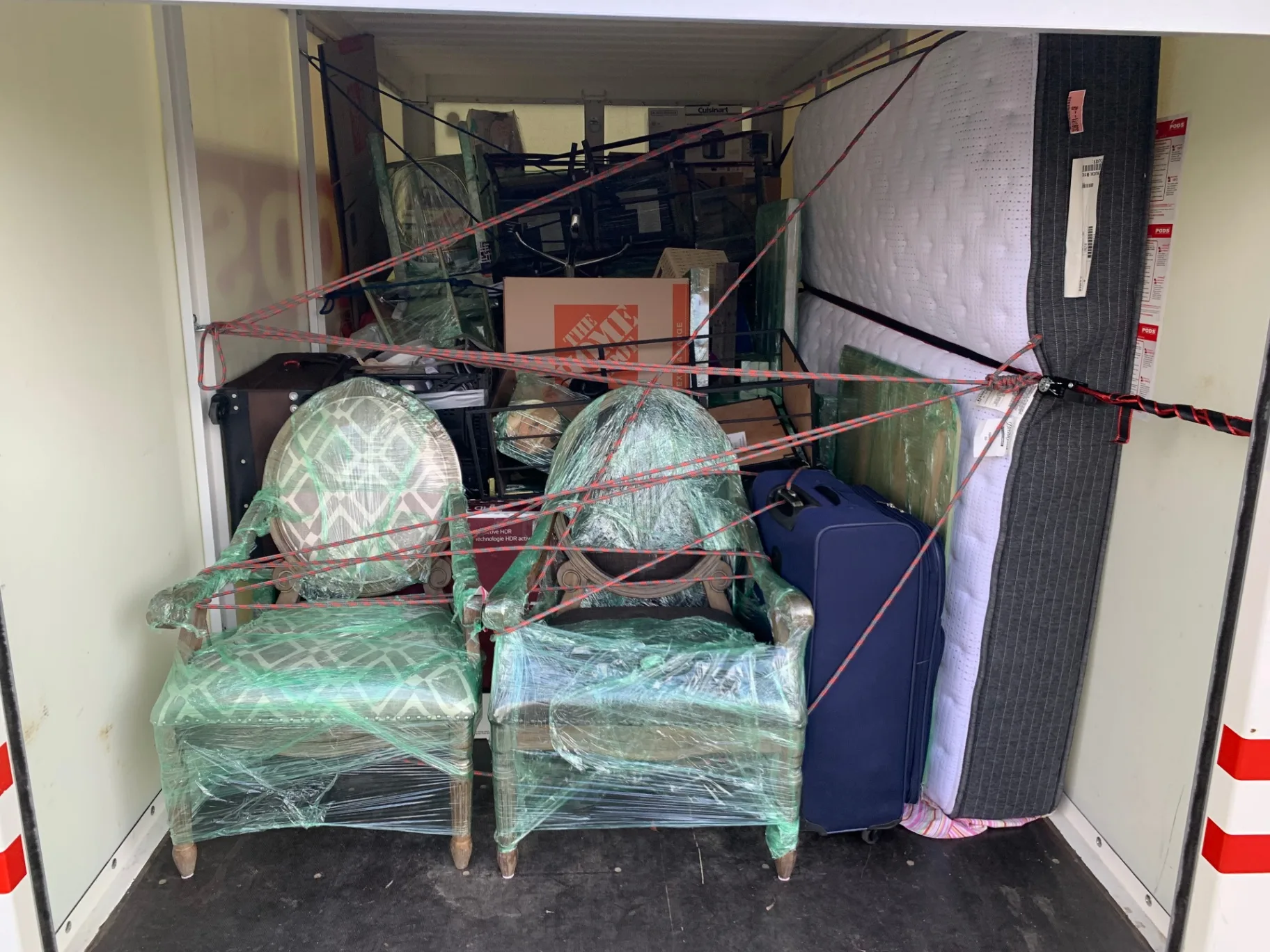 Furniture, mattresses and chairs strapped and secured inside a PODS storage container